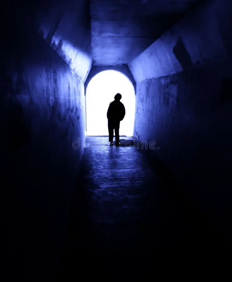 Silhouetted figure walking toward light at the end of a tunnel — a symbol of clarity and transparency